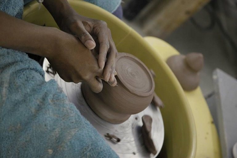 Image: Potter at the potter's wheel at Baltimore Clayworks, one of Baltimore's to contemporary art galleries