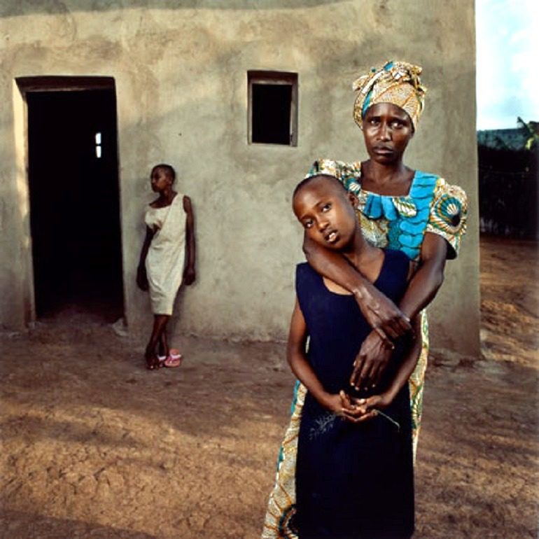 Image: Photography by Jonathan C. Torgovnik (American, b. 1969), titled Valentine with her daughters Amelie and Inez, Rwanda shows a mother taking her daughters out of the war zone in Rwanda