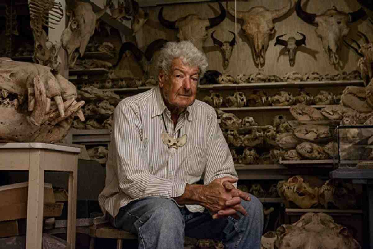 Image- Shows Raymond Bandar sitting with his real animal skulls and bones