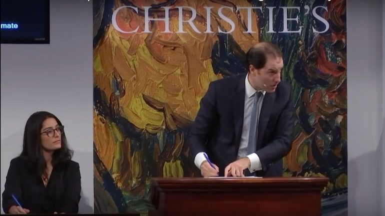 Image: Christie's Auction House auctioneer in action during the live stream of an art auction on its YouTube channel 