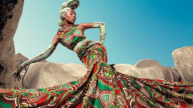 Image: A beautiful women showing off her dress made from wax printed fabrics with bold patterns that has been described as authentic Africa