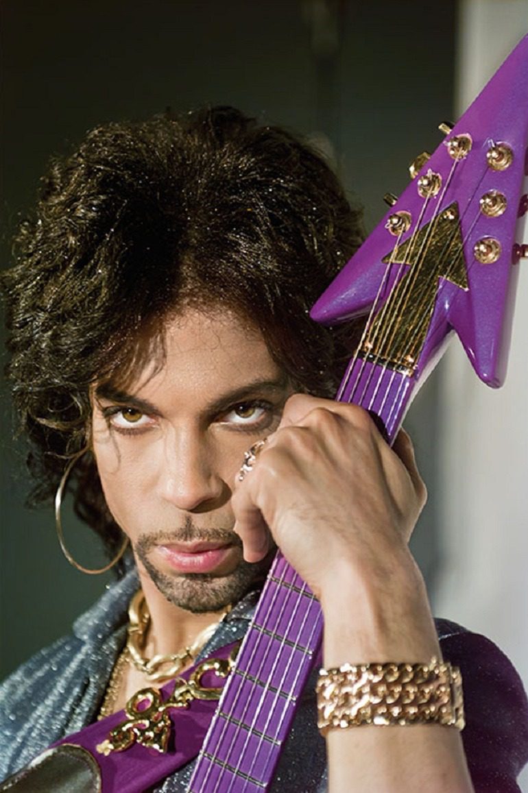 Image of Prince with Love Symbol guitar taken in the 1990’s by Steve Parke, is one of the portrait photographs in Legend Passed