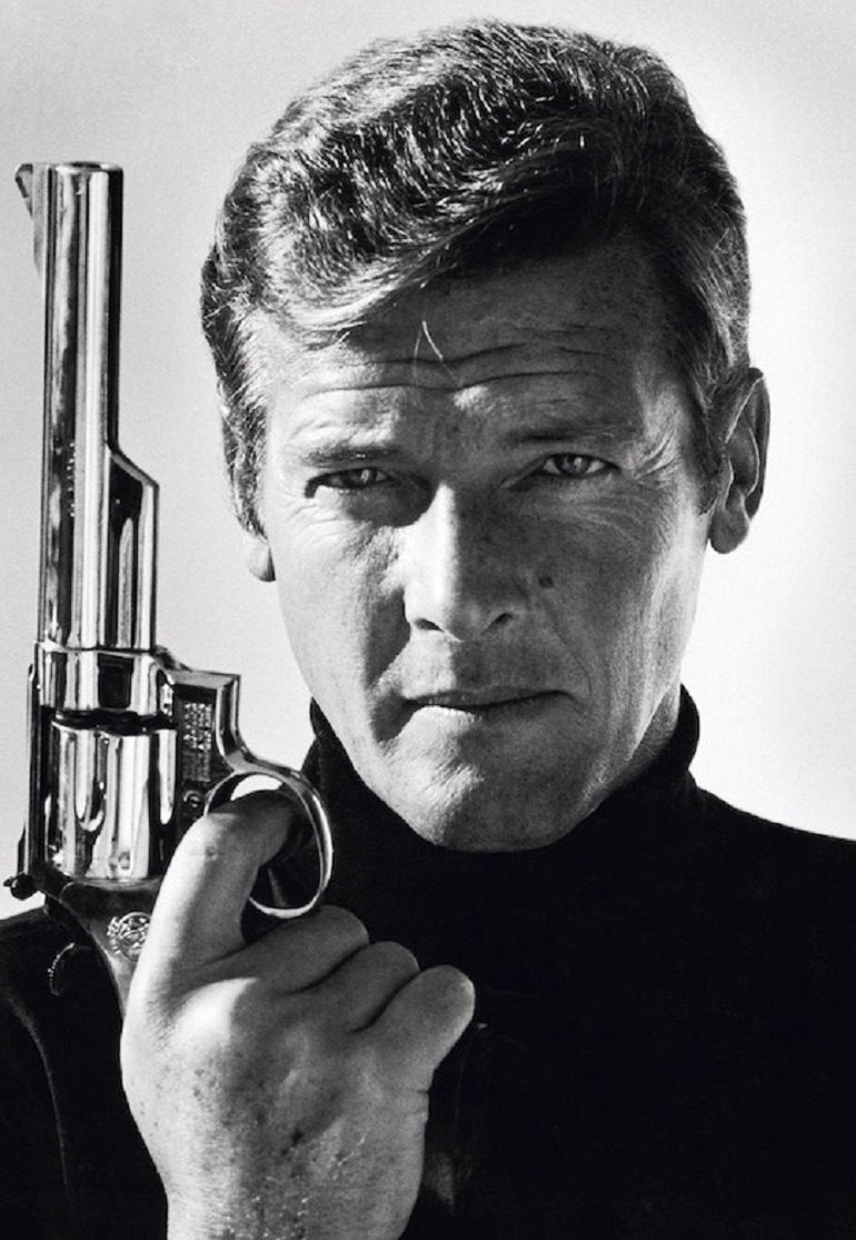 Image: portrait photograph of British actor Roger Moore poses with a gun as James Bond taken in the late 1970s by Terry O’Neill is one of the portrait photographs in Legend Passed