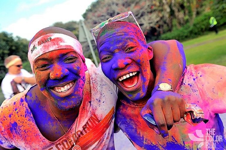 Image: Doused with blue and red colors, two male Color Runners celebrate after The Color Run