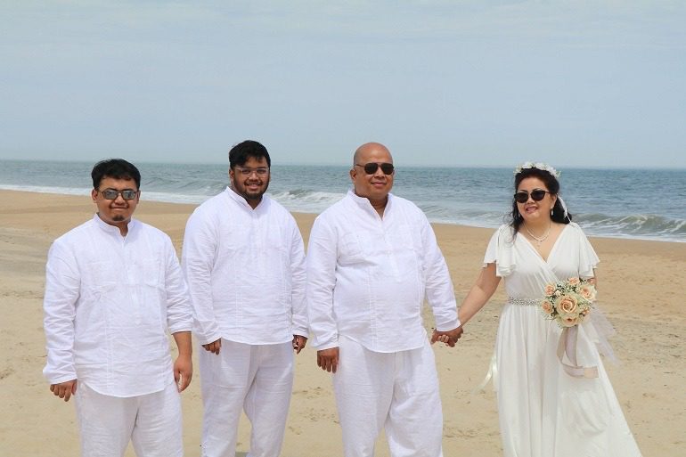 Image: All dressed in white, Dennis, Lilibeth, and their two sons celebrate the 25th Wedding anniversary at the Lewes Beach, Delaware