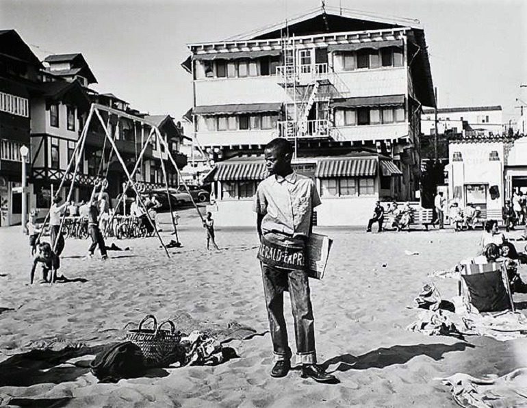 Image: A black and white photograph of Newsboy at the Muscle Beach, Santa Monica, CA, in 1954 taken by Larry Silver 