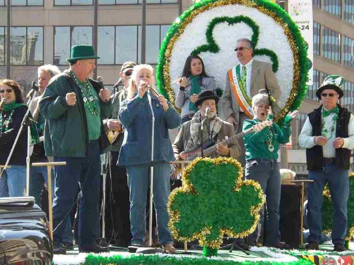 Image: Musicians performing and entertaining spectators on a stage with shamrock designs at the Baltimore St Patrick's Day parade