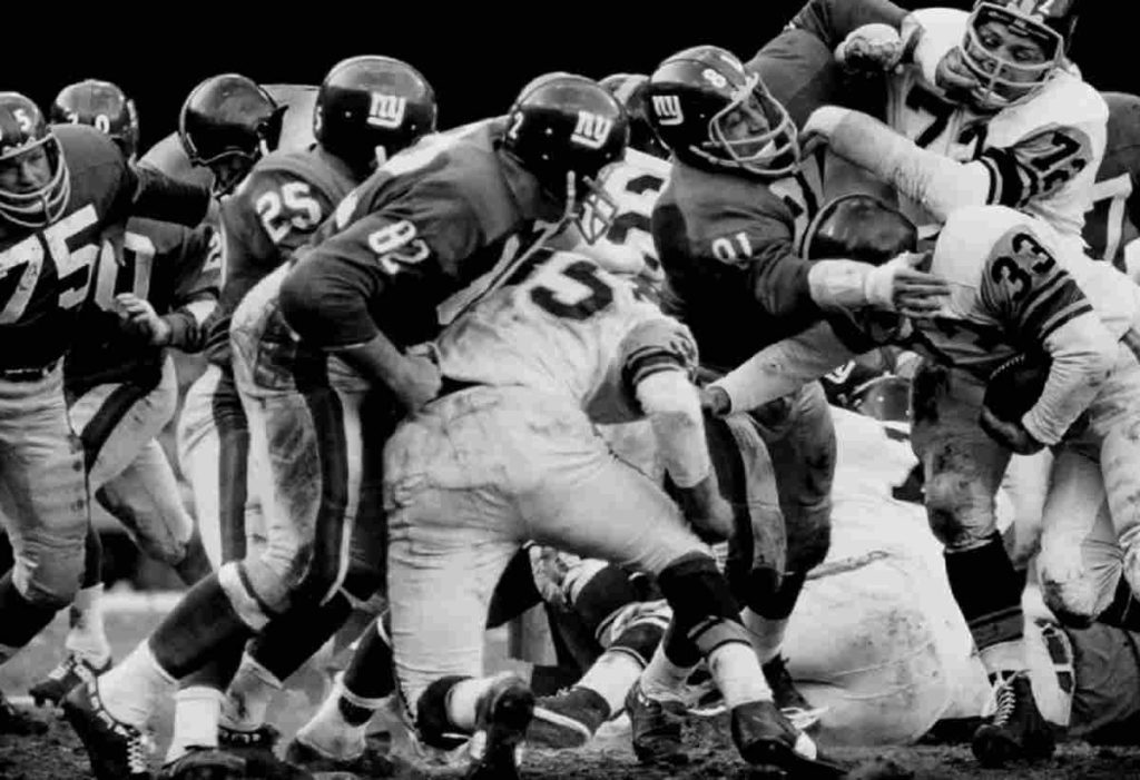 In a football rush, N.Y. Giants vs. Pittsburgh Steelers, Bronx, NY fight it out on the field in a photograph by Walter- Iooss clebrating New York City