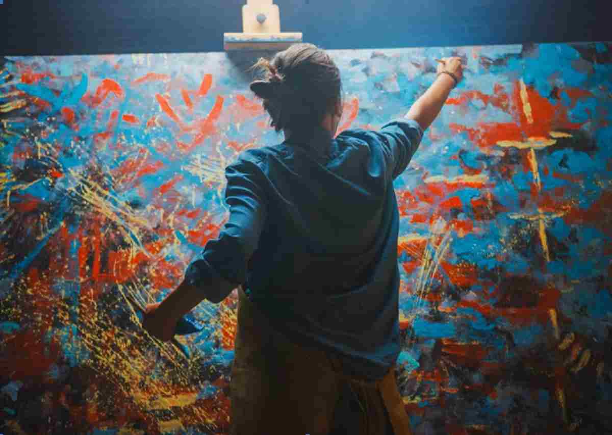 Artist at work painting a large abstract painting. Here are a few tips for making your art stand out from the competition
