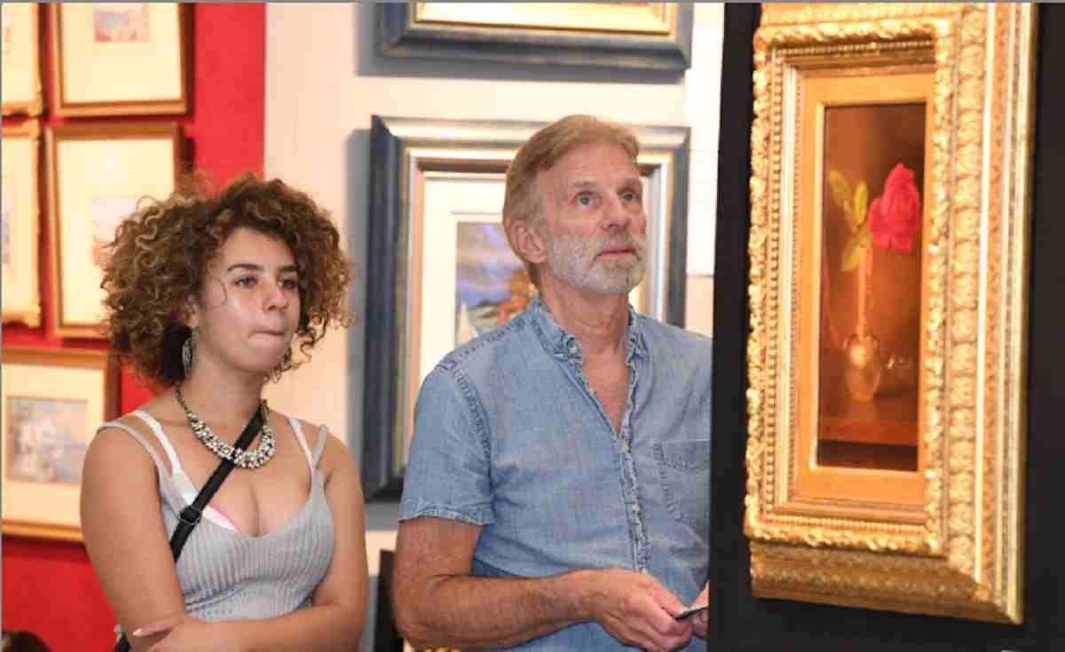 Two guest look at paintings at the annual Baltimore art show