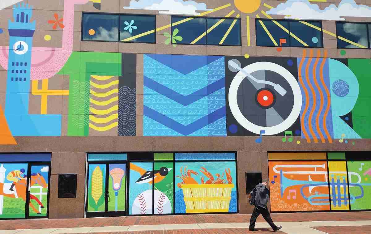 A Baltimorean walks by one of the beautiful new Baltimore murals