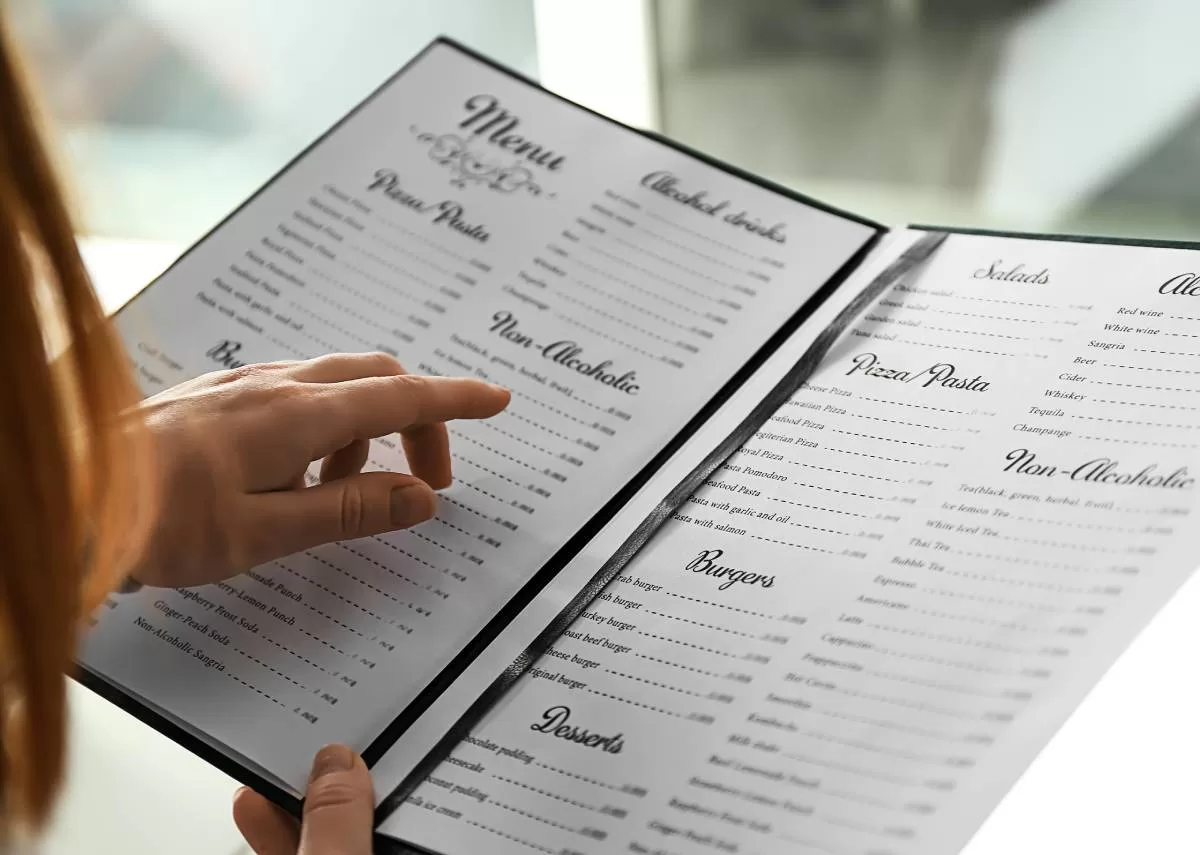 A restaurant diner making their way through the menu and its simplistic design to choose their meal.