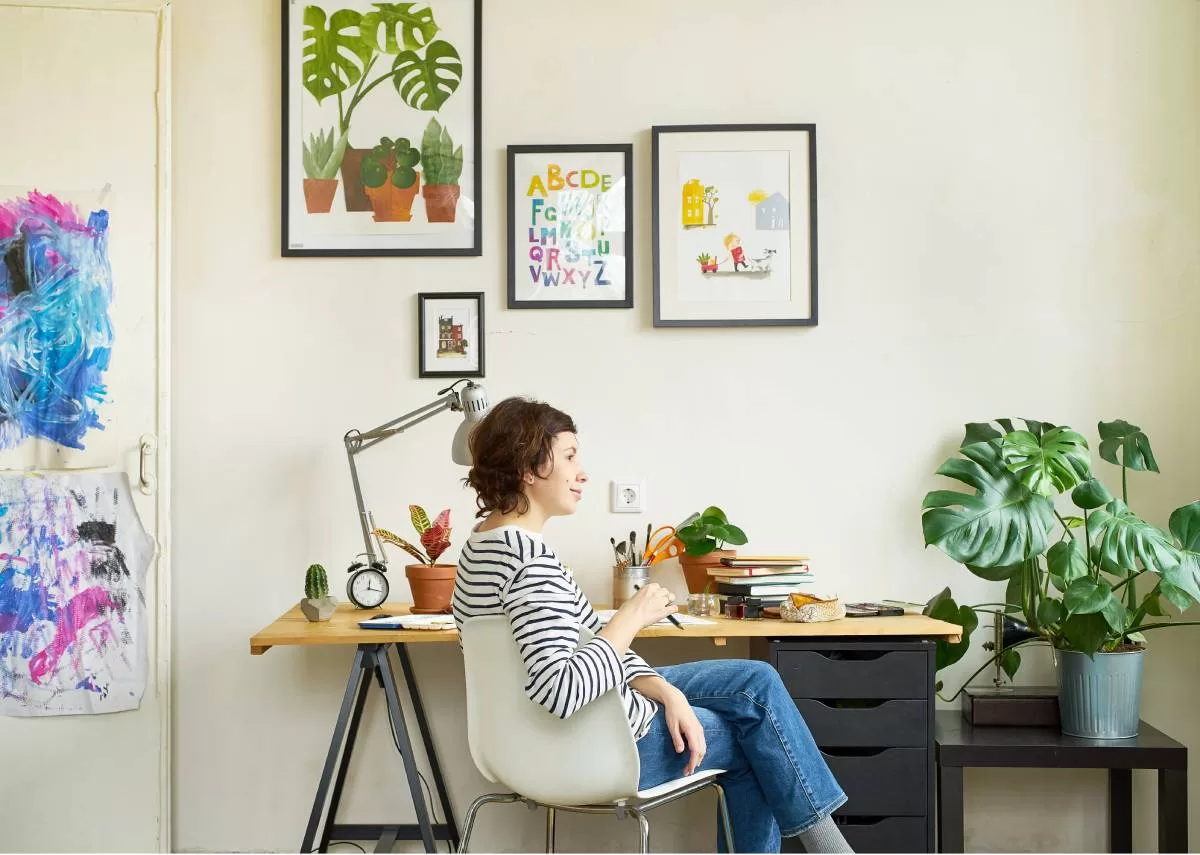 A female artist is sitting in a chair contemplating creating more art for her home. She's enjoying the calming environment in her home. The right colors can turn your home into an artistic haven with color psychology