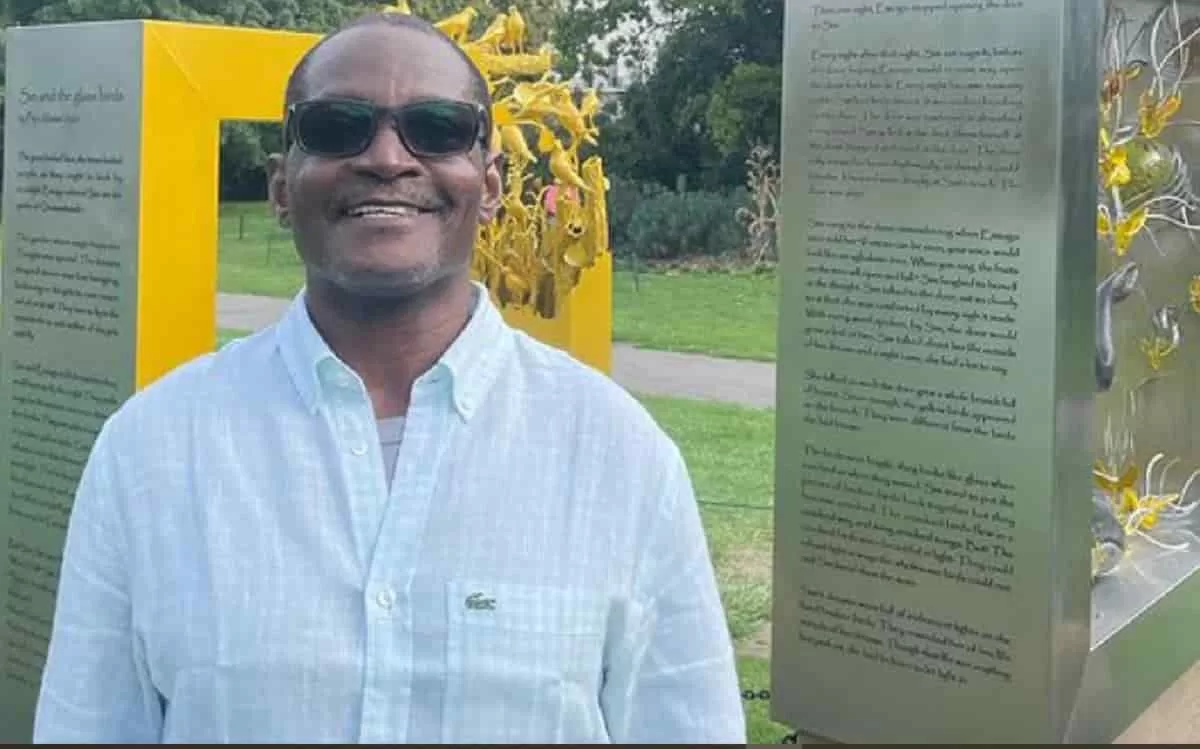 Kainebi Osahenye standing in front of Peju Alatise Public art installation