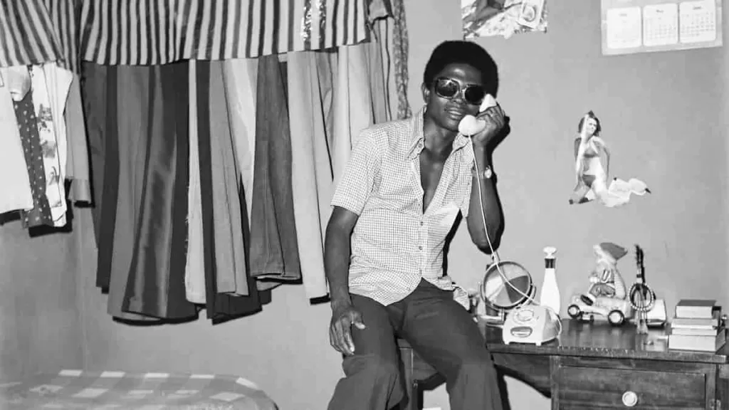 A man poses with a phone in one of Abi Morocco  Photos on Ajisegiri  Street in Shogunle, Lagos, in 1976.