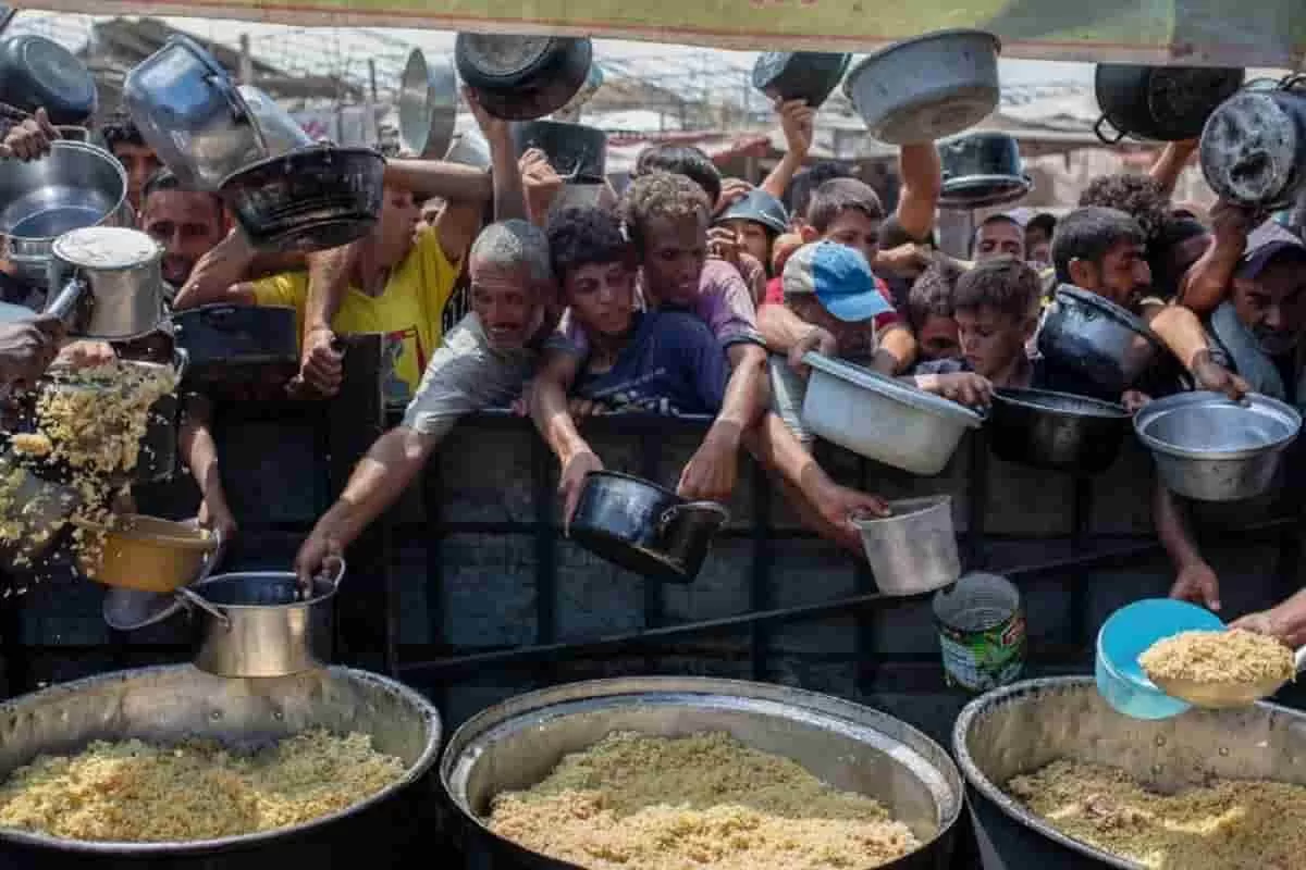 Women, men and children in a crowd rusing for food in Gaza, an image indicative of humanitarian crisis in Gaza