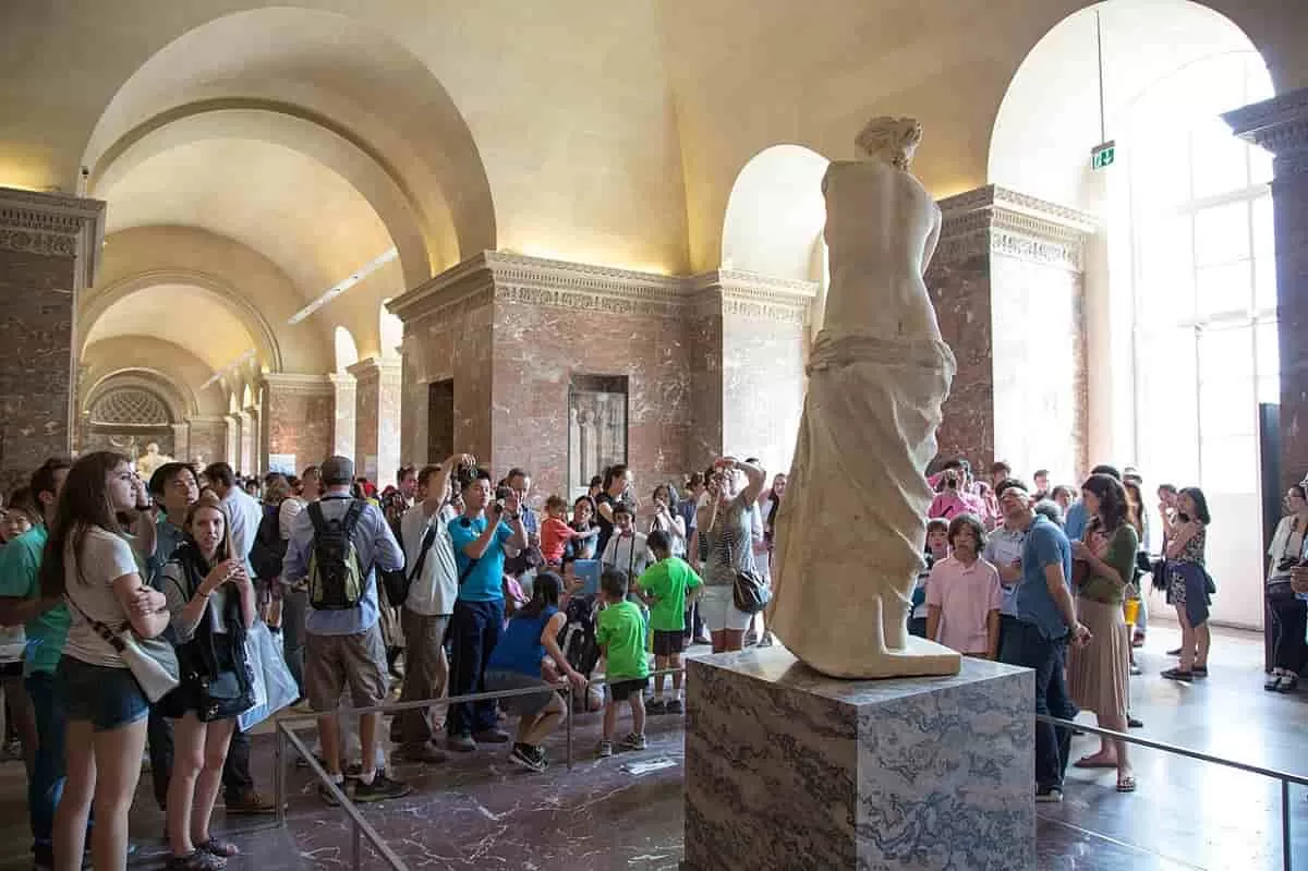 A crowd gathers in front of the sculpture of Venus de Milo at the Louvre. This beautiful female model remains a significant of how artists were exploring the beauty of love in art.