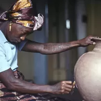 Ladi Dosei Kwali at work decorating a pot. Her work inspired other Black women ceramic artists ho use clay to address topical issues.