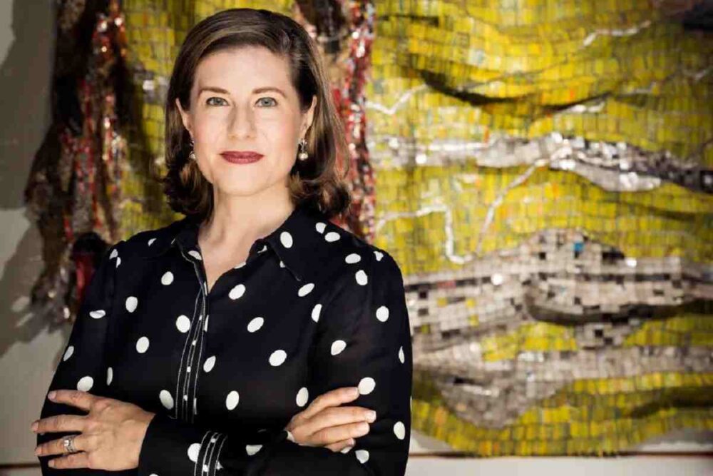 Guggenheim Abu Dhabi Director Valerie Hillings poses for a portrait in front of an El Anatsui artwork created from found objects.