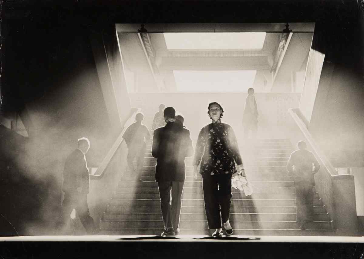 Ho Fan, Smoky World (1959), an example of Pictorialism Photography capturing dramatic light, movement, and human presence in an urban passage.